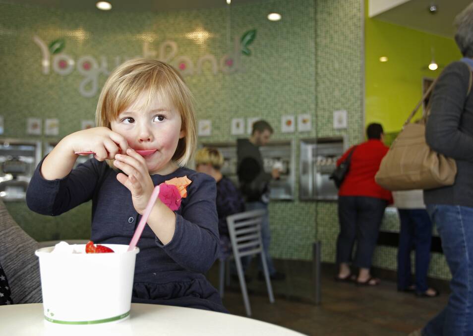 SWEET TREAT: Aurelia Milsom-Drzyzga enjoys her frozen yoghurt at Yogurtland Australia's popular Glendale store. Picture: Marina Neil