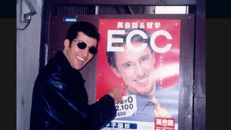 Jeremy Bath in front of a poster featuring Japanese-based English teacher and close friend Scott Neylon. 