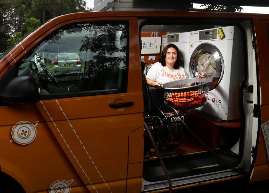 More than laundry: Jordan Wallace, service manager of Orange Sky Laundry, Newcastle, on the job in the orange van dubbed Hunter. 