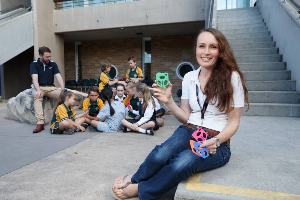 Up tools: Kylie Burrett holds the Splat, which teacher Joe Hamilton is testing with pupils at Holy Family Primary School. Picture: Max Mason-Hubers 