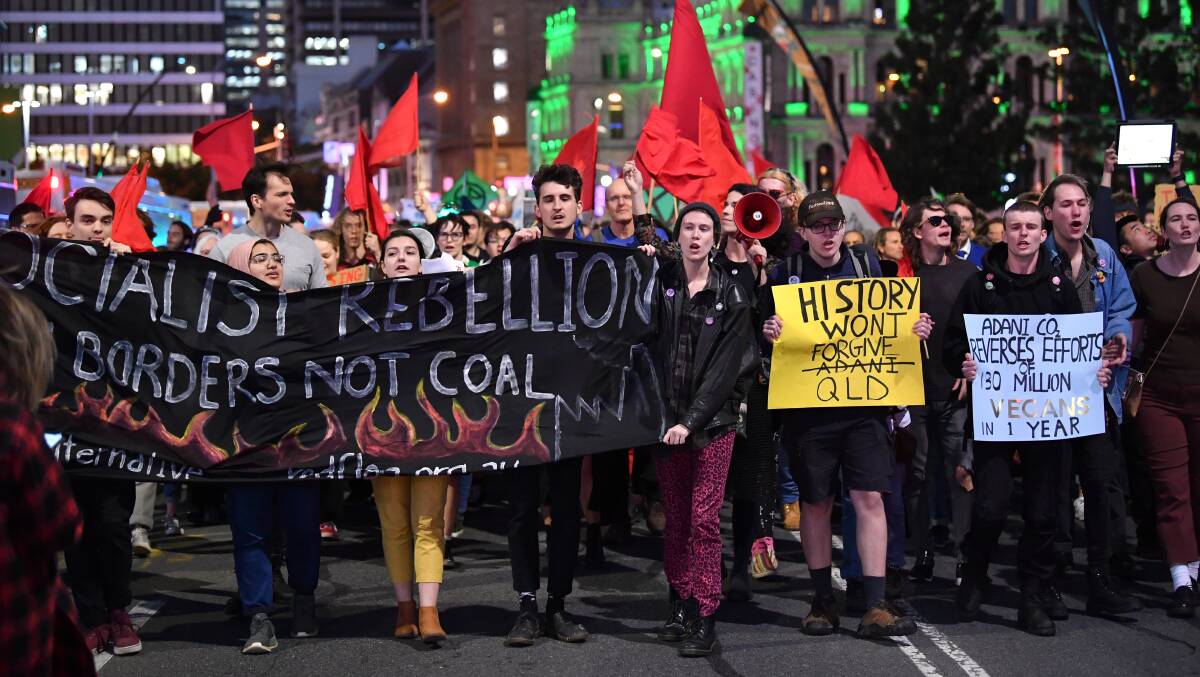 FIGHTING: Climate change protesters march through the streets of Brisbane in opposition of Adani's proposed Carmichael mine in Queensland. Picture: AAP