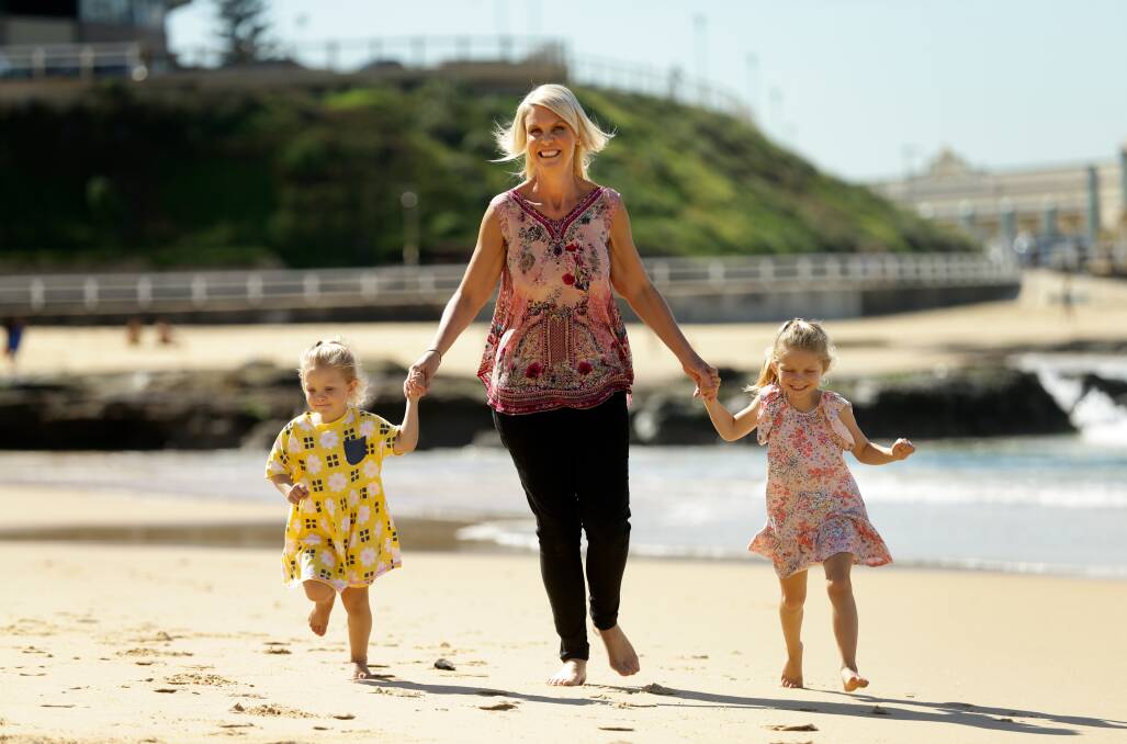 MUM TIME: Belinda MacDougall at Newcastle Beach with daughters Harlow and Mila. Picture: Jonathan Carroll 