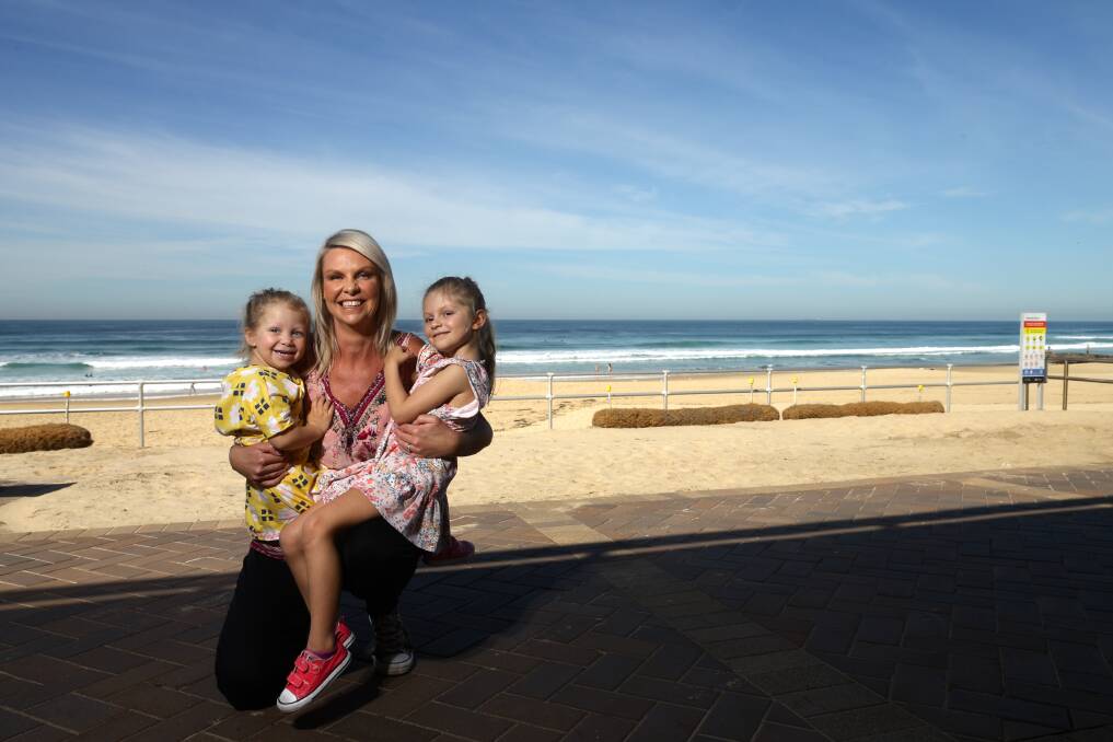  Family business: Belinda MacDougall at Merewether Beach, Newcasle, with daughters Harlow and Mila. Picture: Jonathan Carroll