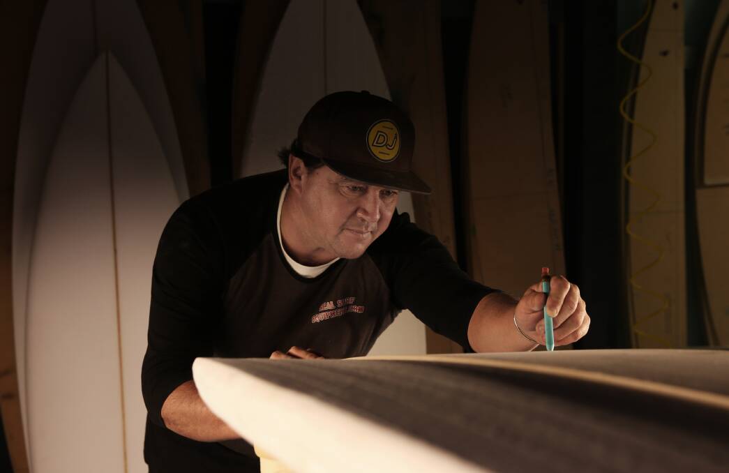 Shape it 'til you make it: Dwane Jefferson drawing an outline on a surfboard in the shaping room of his Mayfield West factory. Picture: Simone De Peak 