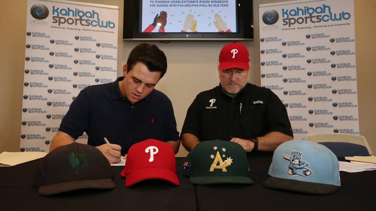 Newcastle baseballer Rixon Wingrove (left) signing with the Phillies in 2018. Picture by Simone De Peak