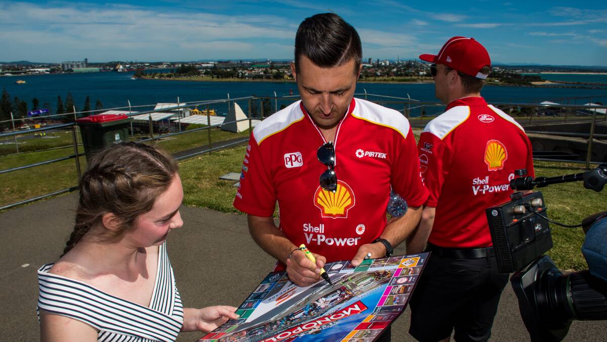 AUTOGRAPHS: Maitland's Maddi Elliott gets her Supercars Monopoly board signed by driver Fabian Coulthard in Newcastle on Tuesday. Picture: Simon McCarthy 