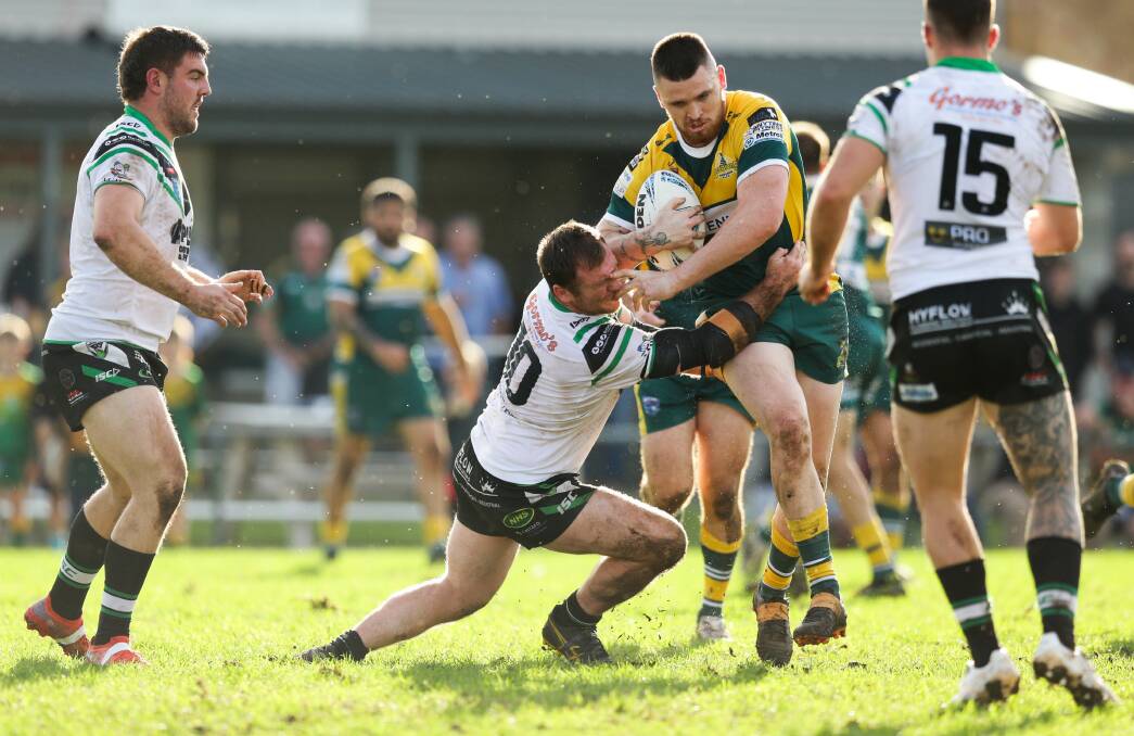 Maitland's James Taylor attempts to tackle Macquarie's Bobby Treacy. Picture by Jonathan Carroll.