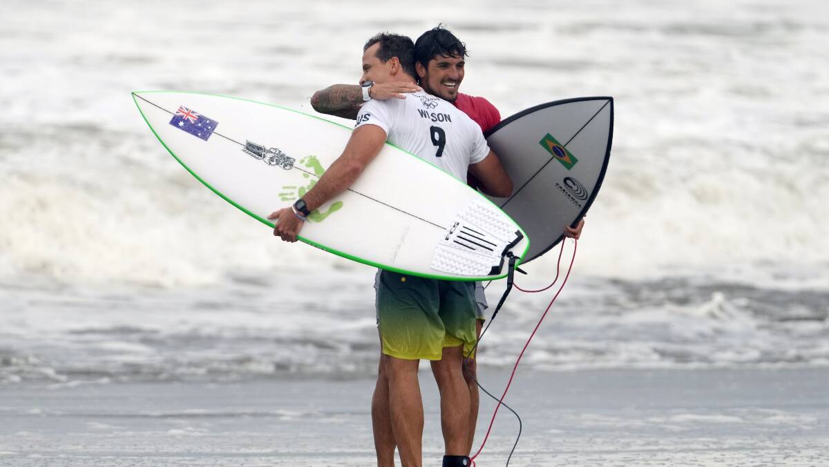 HUGS: Julian Wilson and Gabriel Medina embrace after their round-of-16 heat at the Tokyo Olympics on Monday. Picture: AP Photo/Francisco Seco