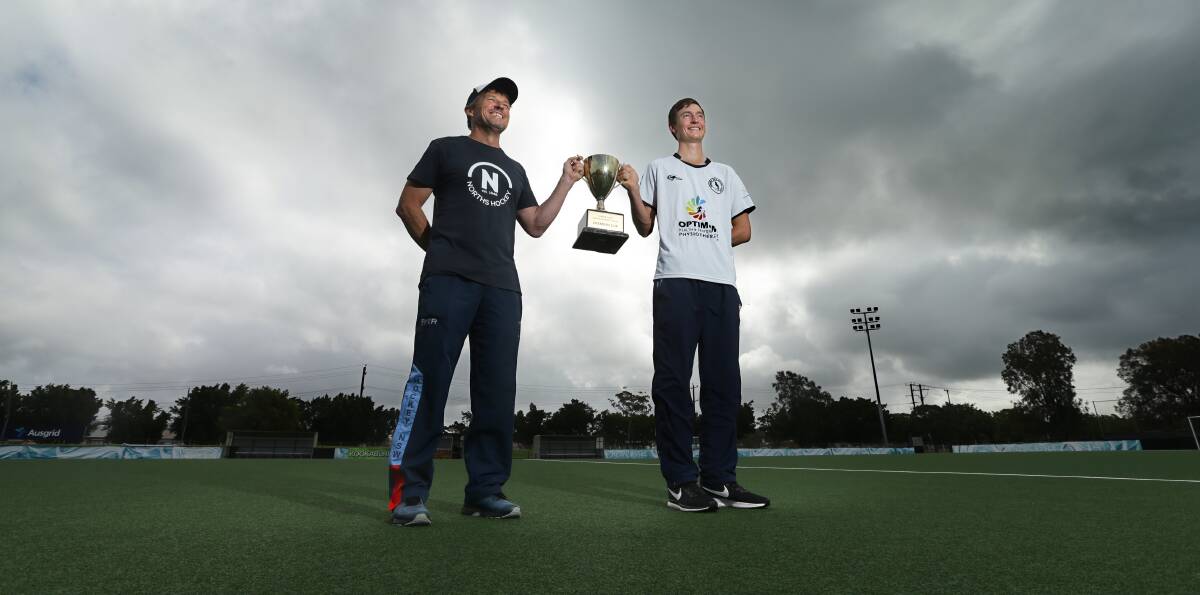 TITLE FIGHT: Norths coach Dave Willott and Gosford player Lloyd Radcliffe with the Hunter Coast Premier Hockey League trophy ahead of Saturday's grand final in Newcastle. Picture: Jonathan Carroll