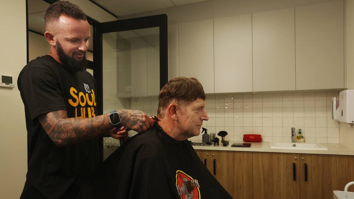 Barber Ben Sabovic cuts Simon's hair at Soul Hub's new home. Picture by Simone De Peak