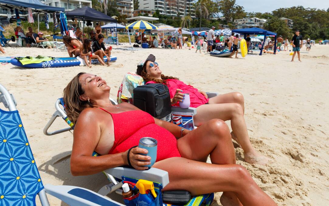 Mary Anas and Melina Xavier enjoy a cold drink on the shore of Nelson Bay Beach. Picture by Max Mason-Hubers.