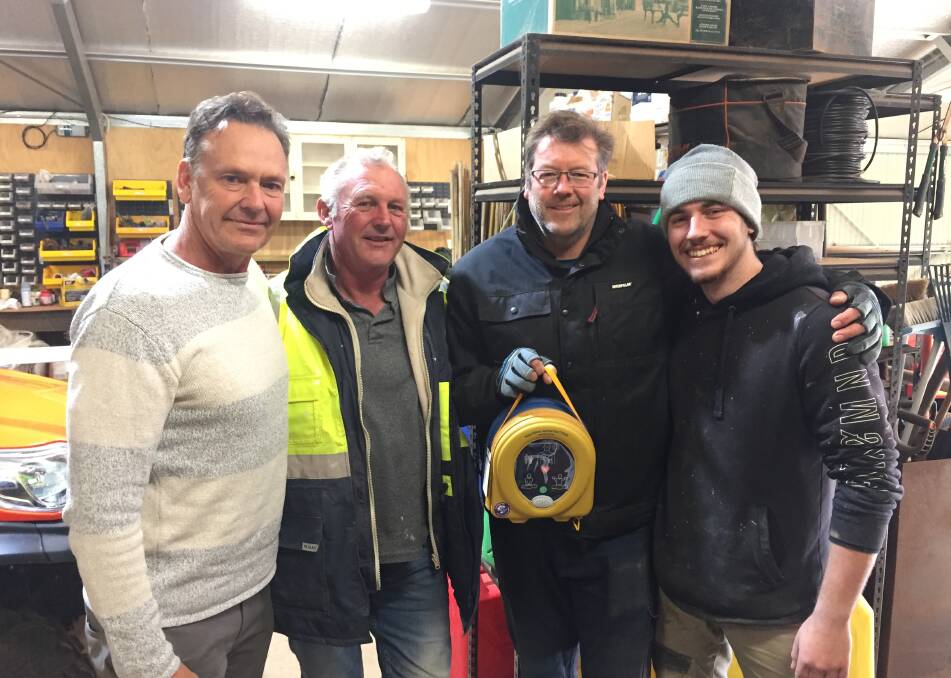 Defibrillator campaigner Guy Leech, Peter Ritchie, Jarrod Olsen and Scott Risson with the defibrillator that saved the life of a mate three weeks ago. Photo: MIchelle Haines Thomas