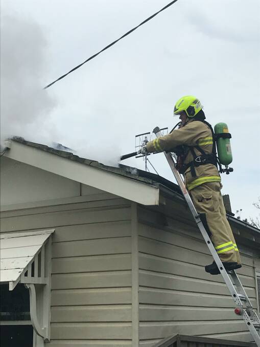 SMOKE IT OUT: A firefighter on scene in New Lambton on Wednesday. Picture: Fire and Rescue NSW