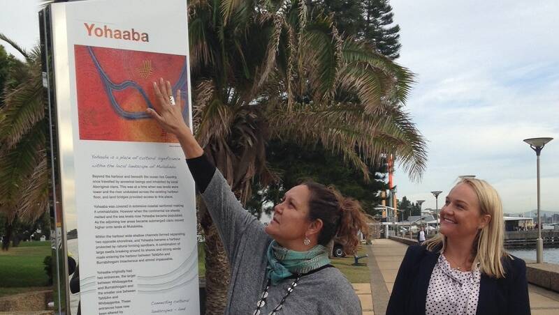 Artist Saretta Fielding, who created artwork for the interactive dual naming signage depicting the Hunter River, joins Newcastle Lord Mayor Nuatali Nelmes to unveil the first of the eight signs on the Joy Cummings Promenade on Monday. 