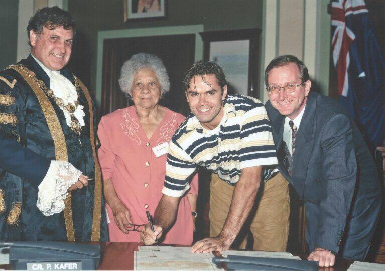 Former lord mayor Cr Greg Heys, Worimi elder Iris Russell, youth representative Rodney Smith and Newcastle council general manager Robert Gibbons signing on in 1999. 