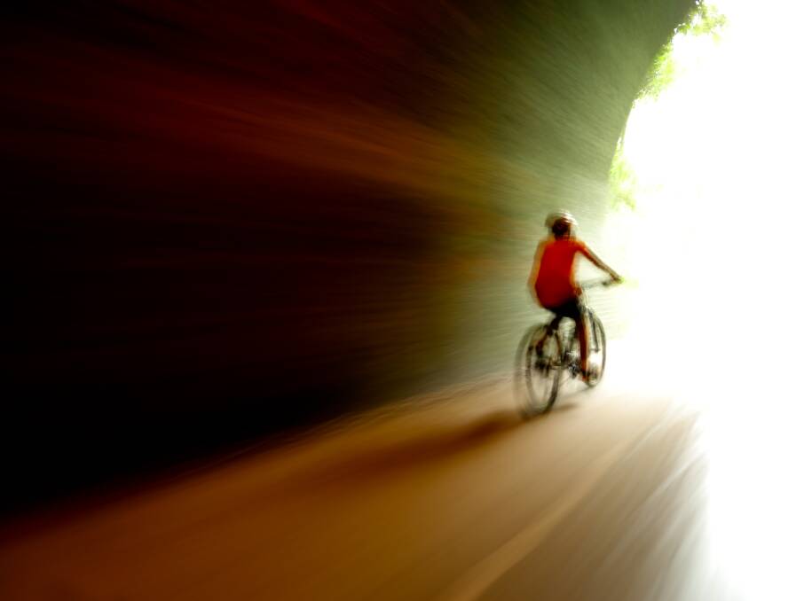 A cyclist rides through the Fernleigh Track's tunnel. Picture by Jonathan Carroll