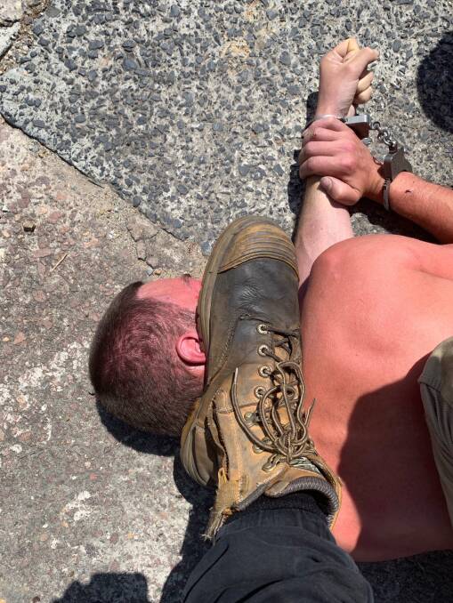 Foot chase: Joel Roberts held his boot on the handcuffed man's neck and another two men sat on his back and legs while they waited for more police to arrive.