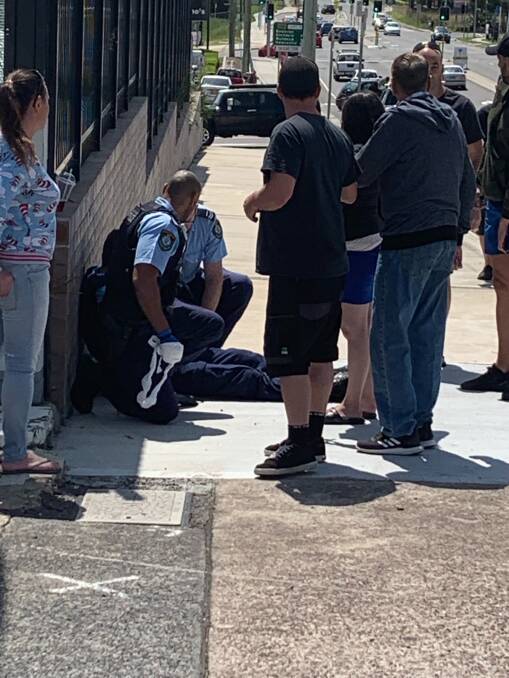 FIRST AID: Police assist one of their colleagues after his injury. Picture: Joel Roberts