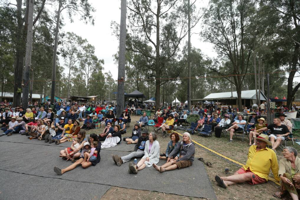 CROWDED HOURS: Music fans sprawl out under the tall trees to watch bands.