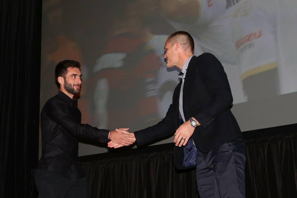 GOOD FORM: Former Jets captain Nigel Boogaard presents striker Beqa Mikeltadze with one of his awards at Newcastle City Hall on Wednesday night. Pictures: Jonathan Carroll