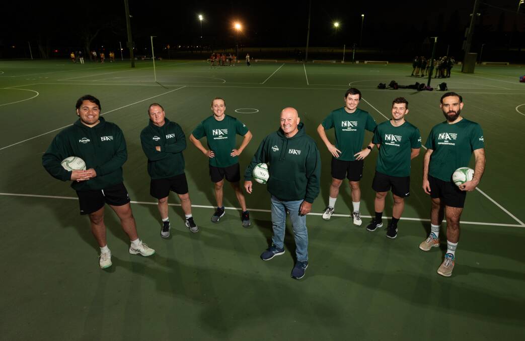 Coach David Huey, centre, and player Tyeson Lalaga, left, with members of the Newcastle men's open netball team. They will contest the NSW titles in Maitland this weekend. Picture by Jonathan Carroll