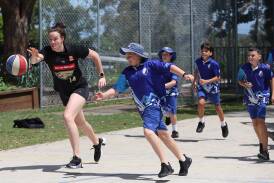 Newcastle's Lara McSpadden, left, was back in town on Friday putting Charlestown South Public School students through their paces as part of a Sydney Flames tour to the region. Picture by Peter Lorimer