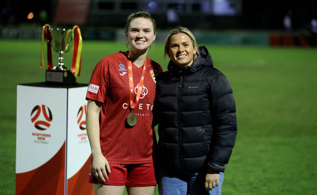 Broadmeadow midfielder Kobie Ferguson, left, was presented her player of the grand final medal by Newcastle Jets captain Cassidy Davis, right, on Sunday night. Picture by Sproule Sports Focus