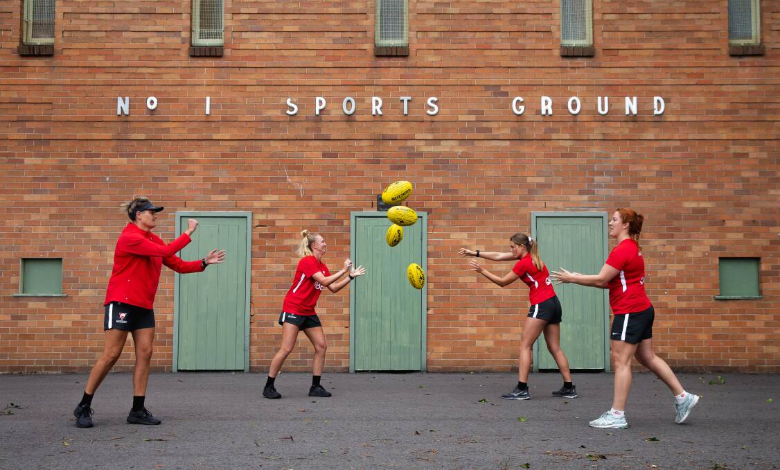 Sydney Swans Academy Red coach Kate Handley (left) passes the ball with players Molly Simpson, London Ashcroft and Taylor Joyce. Picture: Marina Neil