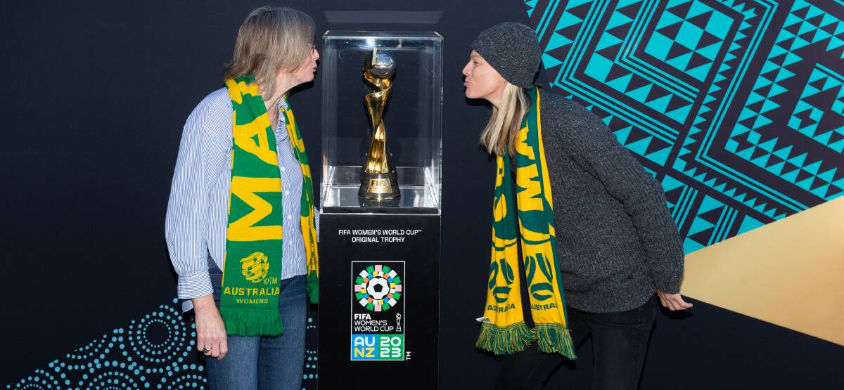 Past Matildas players Renaye Iserief (cap 26), left, and Tracie McGovern (cap 102) get up close and personal with the FIFA Women's World Cup trophy at Speers Point on Sunday. Picture by Jonathan Carroll