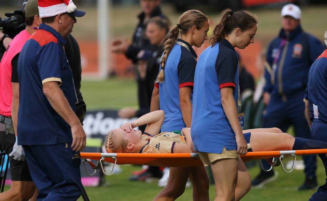 Jets midfielder Murphy Agnew is stretchered from the field before half-time against Brisbane at No.2 Sportsground on Friday night. Picture by Marina Neil