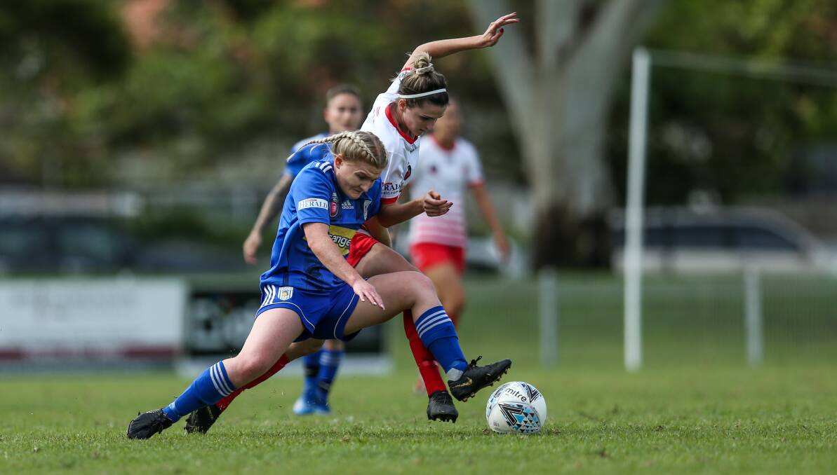 TIGHT TUSSLE: Newcastle Olympic's Jess Evans, in blue, and Merewether's Lori Depczynski vie for the ball in round two of Herald Women's Premier League. Picture: Marina Neil