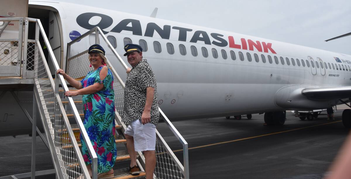 UP AND AWAY: Newcastle Airport ambassadors Mark and Cathy Fren, stars of Channel Nine's Travel Guides show, board a Qantas flight bound for Brisbane on Friday. 