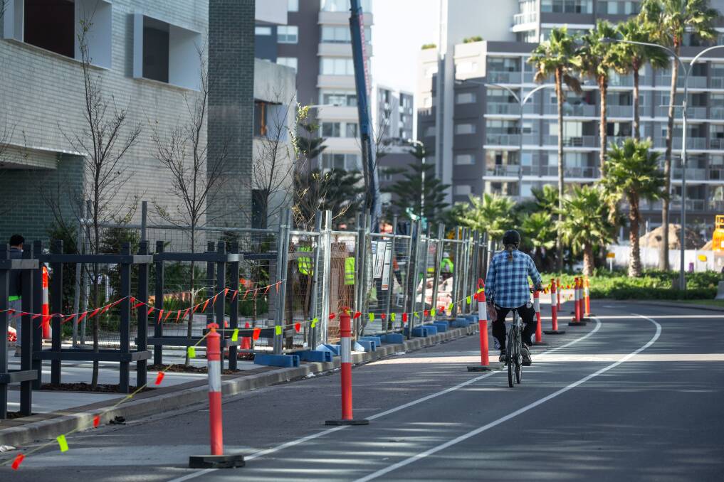 CHANGES: A man rides past construction sites on Honeysuckle Drive where a separated bi-directional cycleway will be built. TPicture: Marina Neil