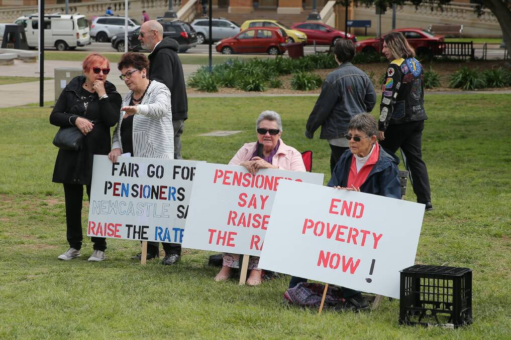 SPREADING THE WORD: Protesters hold placards during the sit-in protest at Civic Park in Newcastle on Sunday. Picture: Max Mason-Hubers