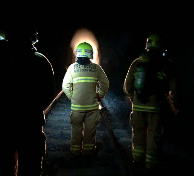 ON THE JOB: Firefighters approach Ardglen tunnel on Sunday. Picture: Sabrina McNamara
