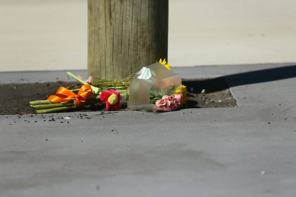 TRIBUTE: Flowers laid near where the woman was hit by the bus. Picture: Jonathan Carroll