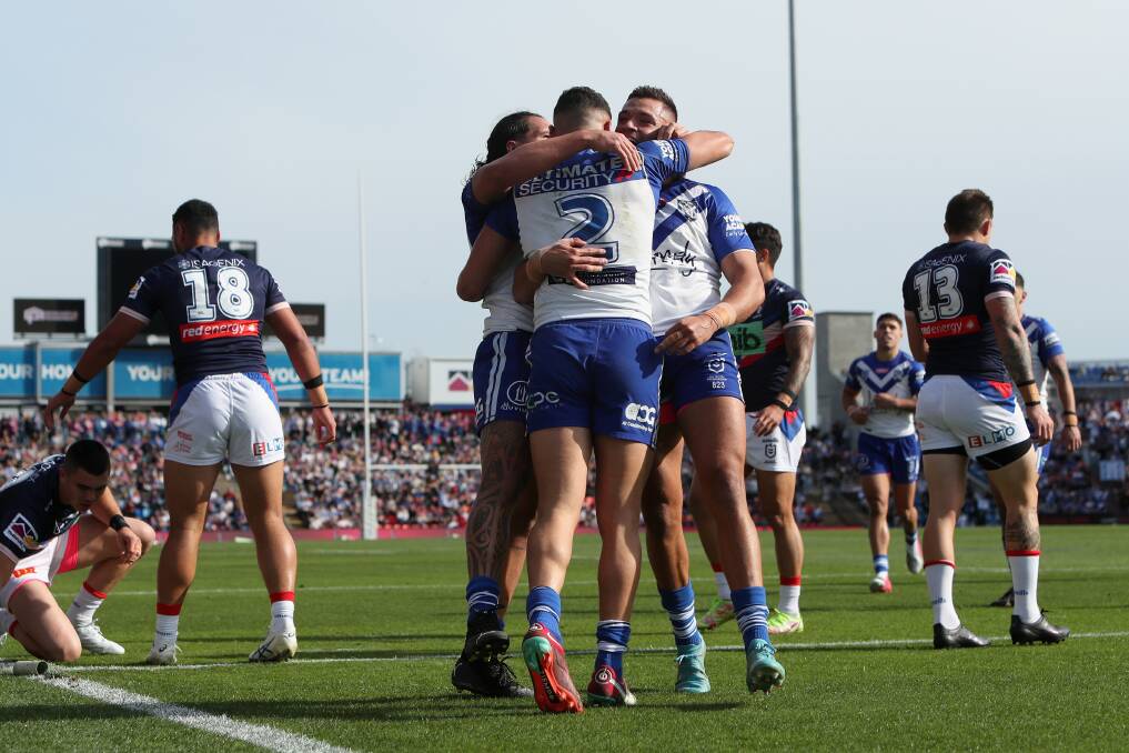 HAT-TRICK: Canterbury players embrace winger Jacob Kiraz, who scored three tries in the Bulldogs' 24-10 victory over Newcastle at McDonald Jones Stadium on Sunday. Picture: Getty Images