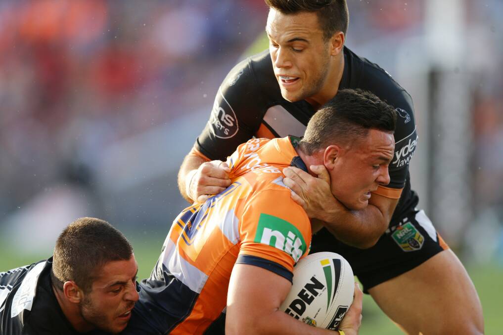 Luke Brooks makes a tackle on former Knights player Jaelen Feeney. Picture by Jonathan Carroll.