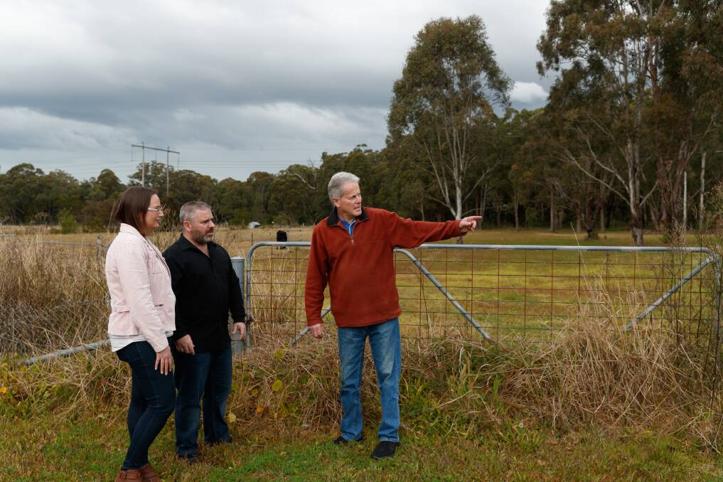 UP IN ARMS: Barnsley's Lee and Jason Harris with fellow Bendigo Street resident Arthur James assessing where the proposed Fassifern to Hexham freight rail line would run at the rear of their properties. Picture: Max Mason-Hubers