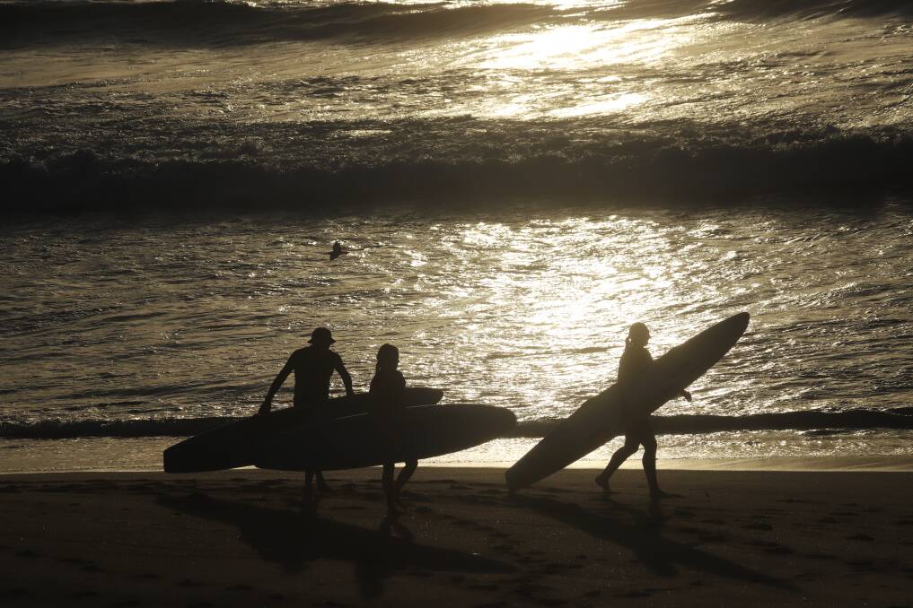 RISE AND SHINE: Morning paddlers on the sand. Picture: Dave Anderson