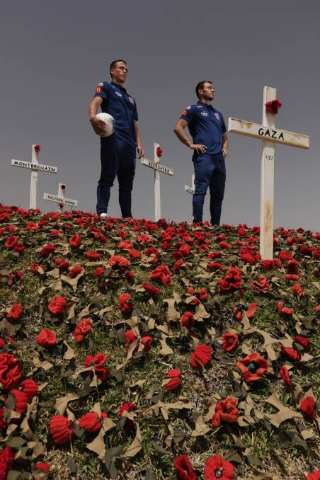 TRIBUTE: Newcastle Jets players Patrick Langlois and Ben Kantarovski among the poppies at Fort Scratchley. 