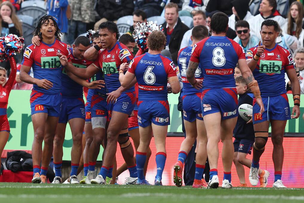 Knights players celebrate with winger Dom Young after he scored one of two tries against the Cronulla Sharks at McDonald Jones Stadium on Sunday. Picture by Getty Images 