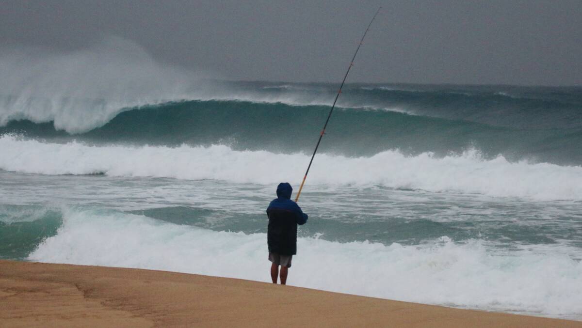 SURF'S UP: A fisherman at Bar Beach on Friday. Picture: Dave Anderson