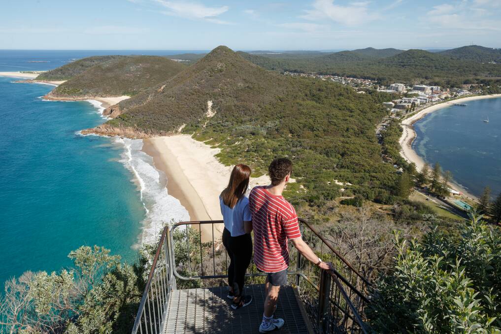 OUR BACKYARD: Tourists take in the view of Shoal Bay and Zenith Beach from atop Mount Tomaree. Port Stephens is expected to attract plenty of day-trippers. 