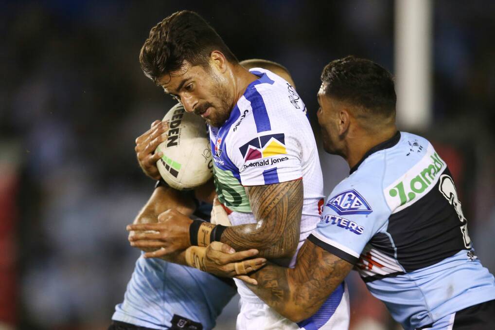 WRAPPED UP: Tuala being tackled by Cronulla players last week. Picture: Getty Images 