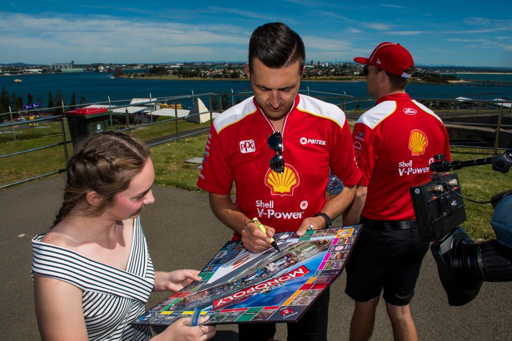 Supercars driver Fabian Coulthard signs a poster for a fan. Picture: Simon McCarthy