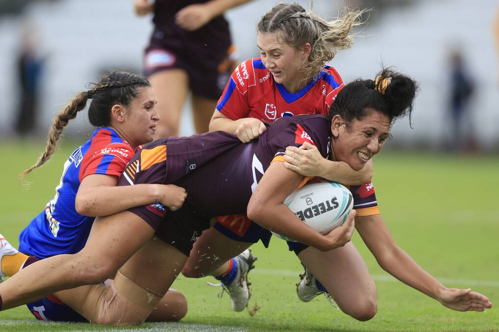 TOUGH DAY: Newcastle Knights utility Emma Manzelmann comes across the top to bring down Brisbane Broncos forward Kaitlyn Phillips at WIN Stadium in Wollongong on Sunday. Picture: Getty Images 
