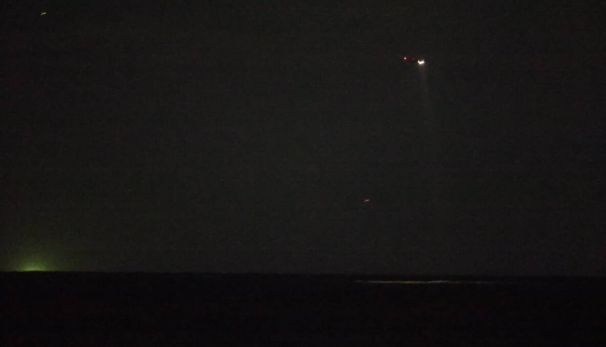 SEARCH: A helicopter searches the water on Friday night. Picture: Marina Neil