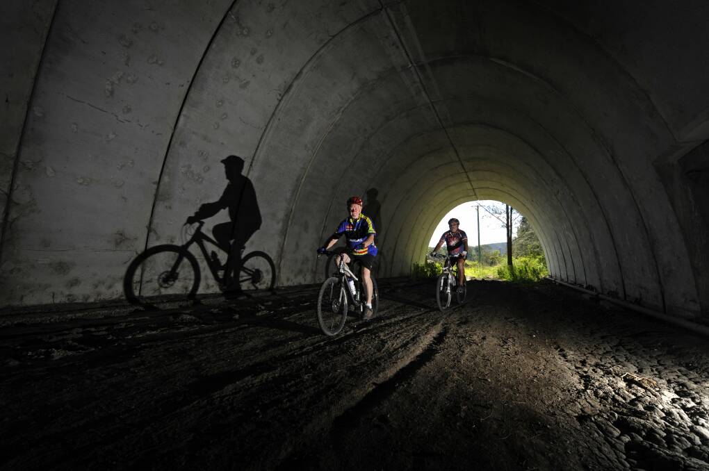 PUSHING AHEAD: Cyclists David Atkinson and Billy Metcalfe ride through a tunnel on part of the planned Richmond Vale Rail Trail in 2013. Picture: Marina Neil