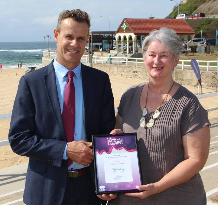AWARDED: Newcastle state MP Tim Crakanthorp with 2018 Newcastle Local Woman of the Year Michelle Lancey at Nobbys beach on Monday. 